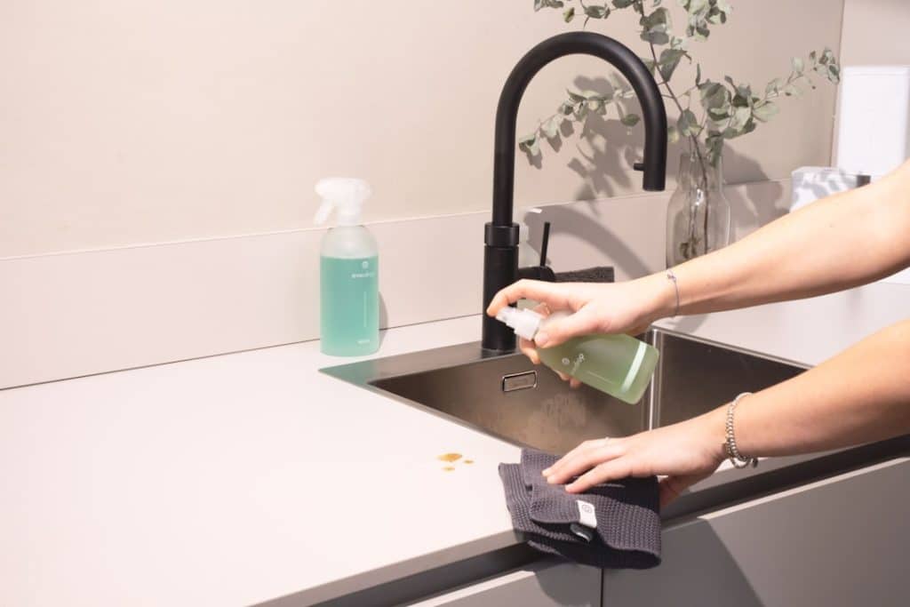 a-woman-is-cleaning-a-kitchen-sink-with-a-rag-sqomdoqb3ws